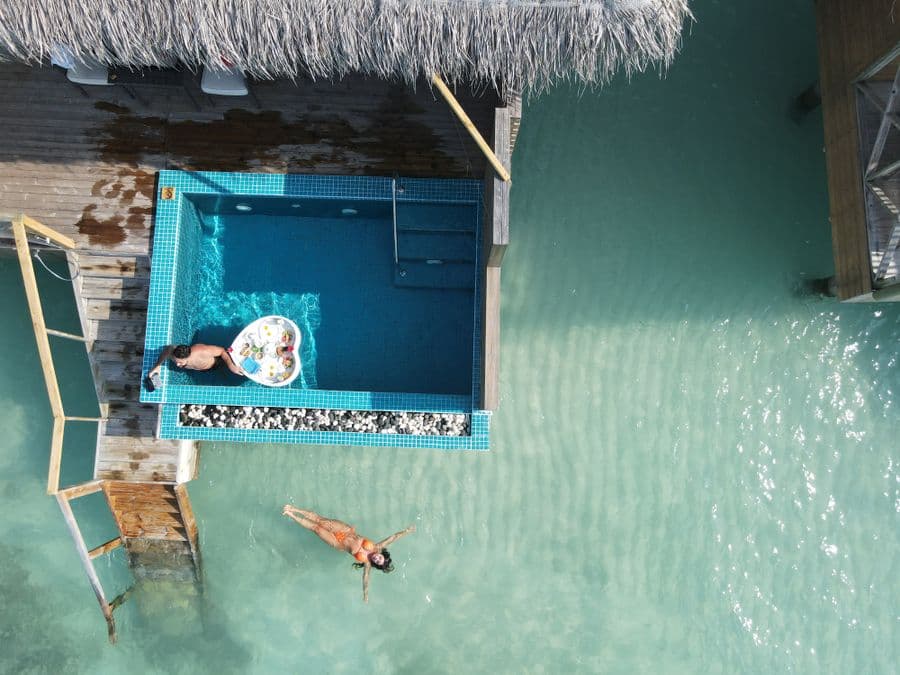 Private plunge pool and a couple relaxing beside a turquoise lagoon